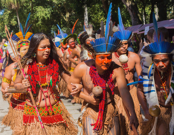 Encontro de indígenas com seus itens e trajes típicos, elementos da cultura brasileira.